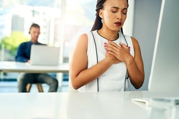 Woman holding her heart, representing some heart disease issue