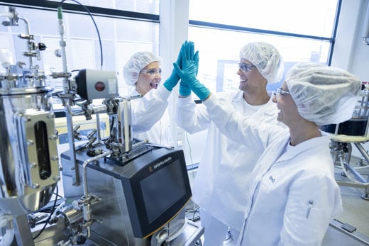 Teva employees high fiving each other in manufacturing