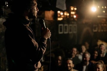 Young caregiver performing stand-up comedy as his new passion