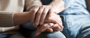  A close-up of two elderly individuals holding hands, symbolizing connection and gratitude in their daily practice.