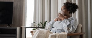 A woman seated with a cup of tea, representing tranquility and the significance of maintaining lung health in COPD awareness.