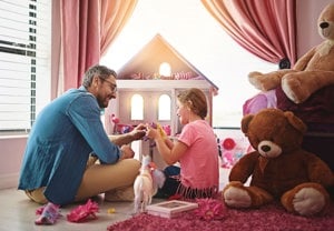 Man and daughter playing with dolls as a fun caregiving preparation activity