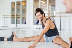 Man with ADHD sitting and laughing during a yoga group session