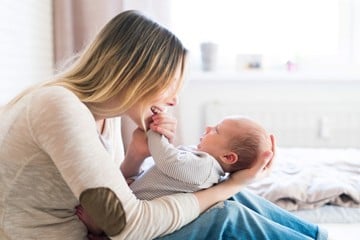 New mother cooing over her newborn son