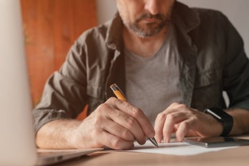 Caregiver Working On His Schedule For The Next Few Days Using His Phone Calendars And Organization Apps