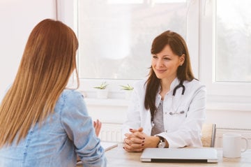 Female migraine patient discussing the condition with her sympathetic healthcare provider.