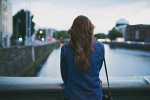 Lone woman facing road, symbolizing the difficult journey ahead