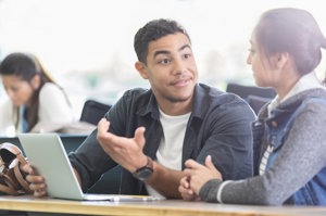 Man with ADHD converses with a colleague at work.