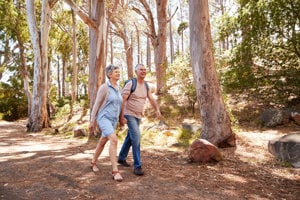 Middle-aged couple with COPD walking in the woods to keep fit and healthy