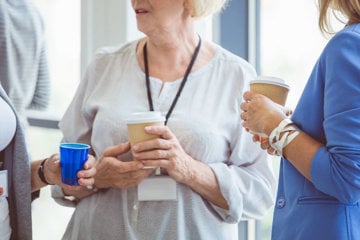 Woman having coffee with colleagues and informing them of her COPD diagnosis.