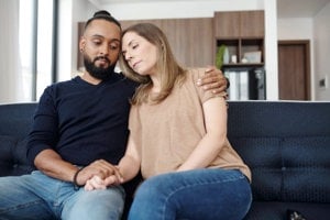 Young couple comforting one another in the aftermath of cancer treatment