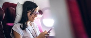 Woman on plane checking for pet updates before take-off